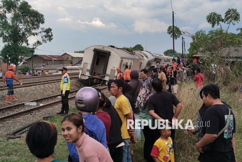 Warga mengamati gerbong belakang dari Kereta Api Purwojaya relasi Gambir – Kroya yang mengalami anjlok di Emplasemen Stasiun Kedunggedeh, Kabupaten Bekasi, Jawa Barat, Sabtu (25/10/2025). PT KAI masih menyelidiki penyebab anjloknya gerbong kereta api jarak jauh itu serta menutup jalur guna memastikan keamanan perjalanan kereta api lainnya.